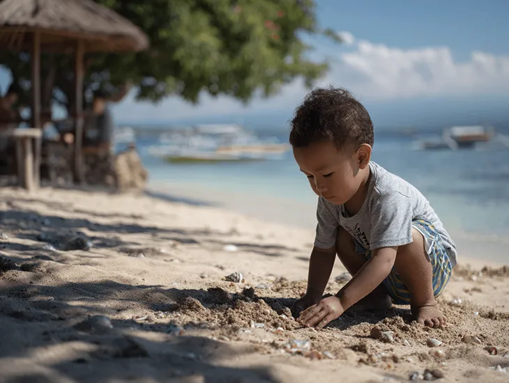 Nusa Lembongan Safety 2026 – Parents supervising toddlers during sand play while avoiding the dangerous surf