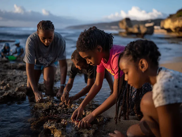 Pecatu Beach Recreation 2026 – Older children and teenagers walking along the wide shoreline of Nyang Nyang Beach while wearing protective water shoes.