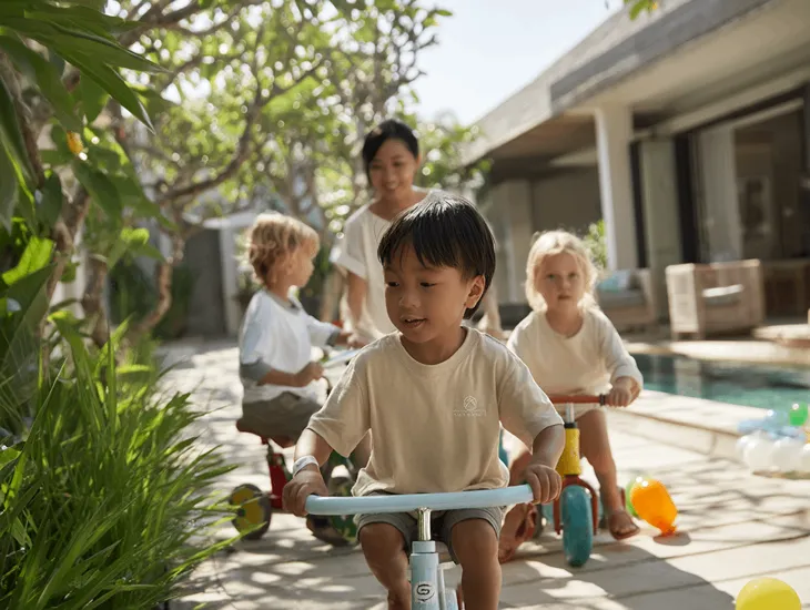 Family-Friendly Hotels Bali 2026 – A professional travel assistant playing educational games with two toddlers in a hotel kids' zone.