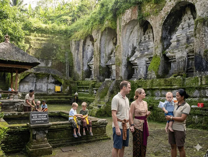 Gunung Kawi Temple in Bali 2026 – Specialized travel assistant using a baby carrier on winding valley stairs.
