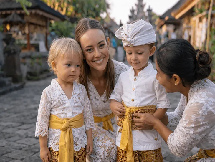 Cultural Costumes in Indonesia 2026 - Young children wearing traditional Balinese outfits on a cobblestone street