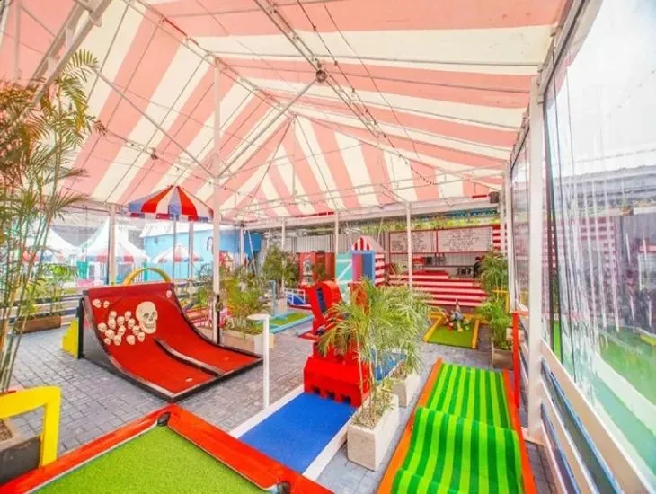 family mini golf in Bali 2026 – A professional travel assistant showing a teenager the correct overhand grip for an axe-throwing session.