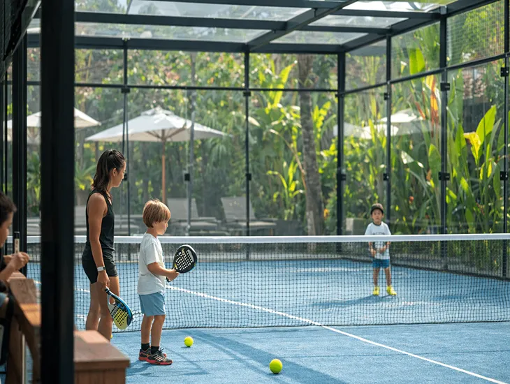 Kids Padel Pickleball in Bali 2026 – A group of school-age children practicing volleys on a scenic covered court surrounded by tropical greenery.