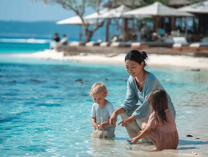 2026 – Families playing in the shallow, turquoise waters of Mushroom Bay in Indonesia.