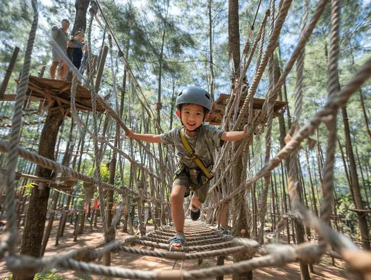 Outdoor Activities in Bali 2026 – A professional instructor checking the double-harness system for a child before a zipline flight.