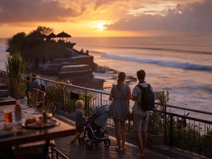 Childcare Services in Indonesia 2026 – Assistant walking with a toddler on a paved path near the ocean.