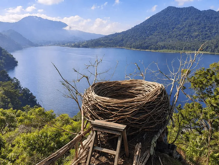 Highland Scenery 2026 – Childcare provider in Bali helping a toddler into a safe bamboo nest for a family photo.