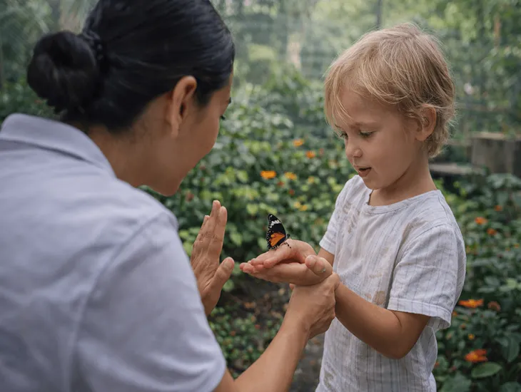 Insect gardens in Bali 2026 – A childcare specialist helping a child gently hold a butterfly.