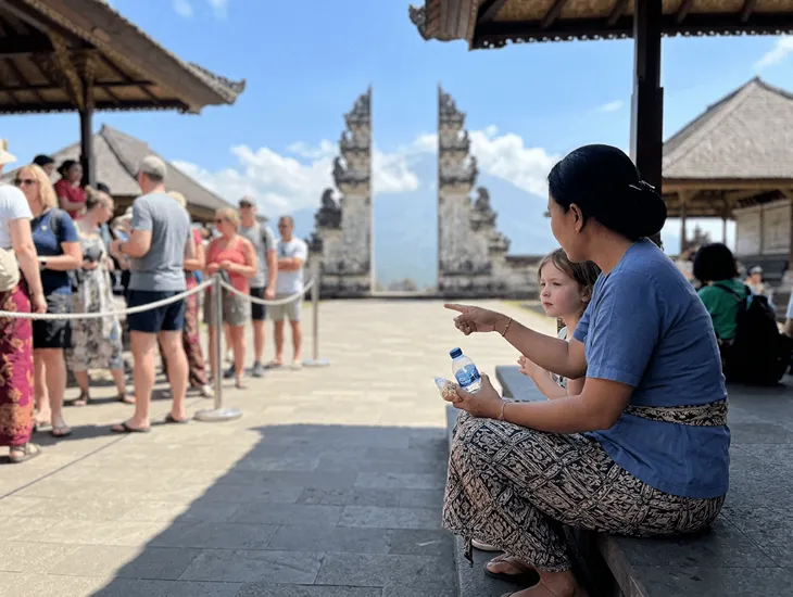 Temple Etiquette in Bali 2026 – Professional caregiver keeping a child engaged with a quiet game.