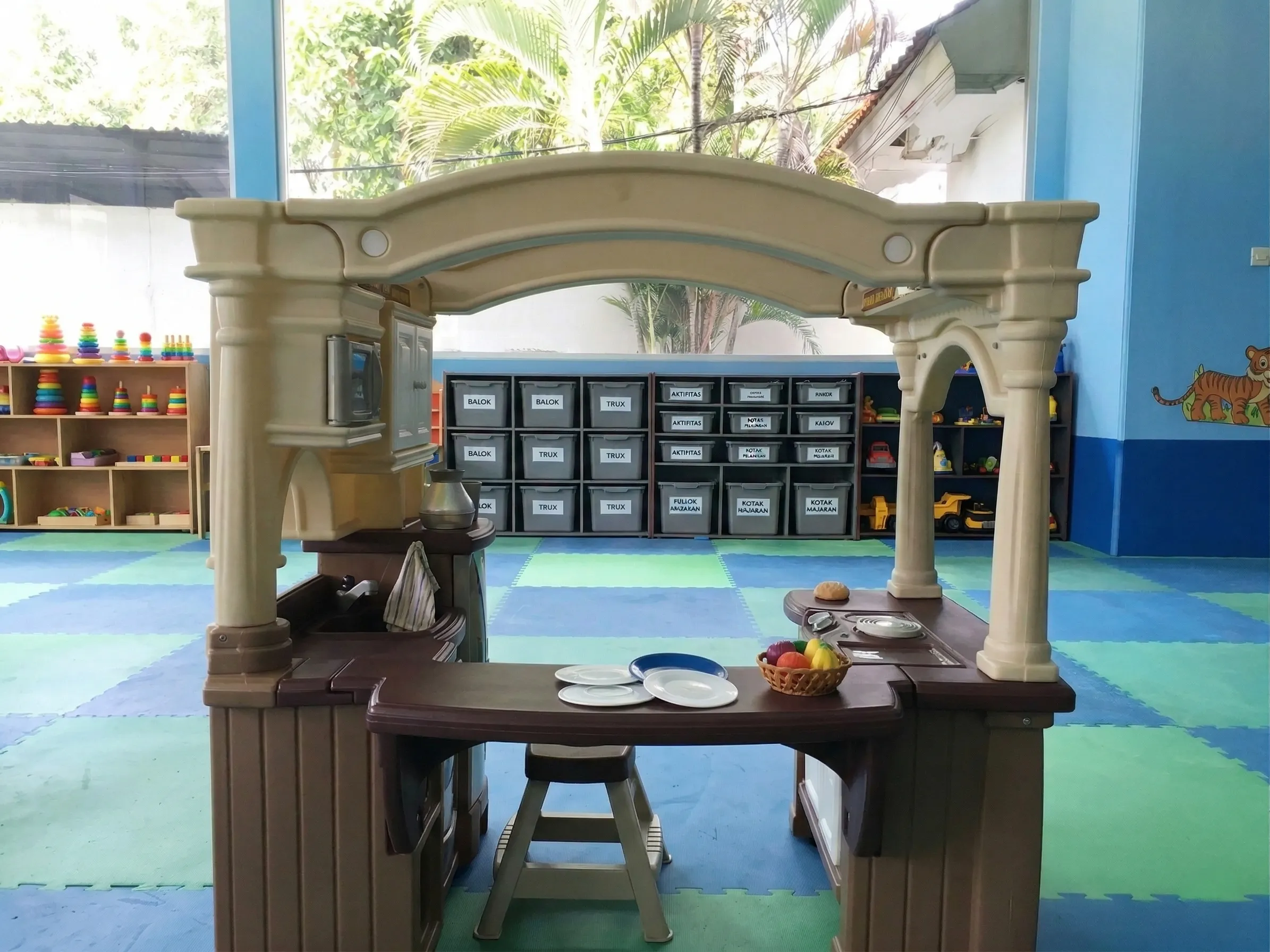 Family trip in Indonesia 2026 – Professional caregiver helping young children share toys safely.