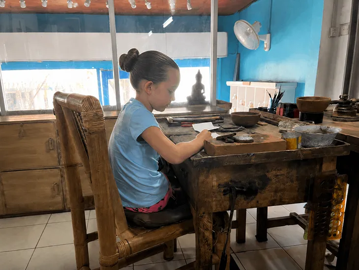 Studio Perak Ubud 2026 – Teens focusing intently on their silver hammering techniques in the studio