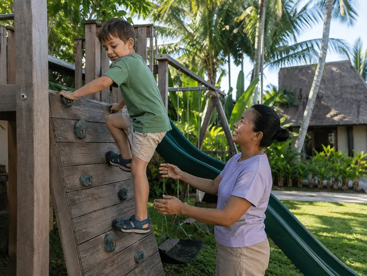 The 6Cs of Education 2026 – Child climbing a small playground structure safely in Bali with help