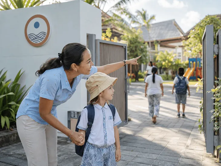 School Transition Support 2026 – Babysitter in Indonesia guiding a child through a new school gate